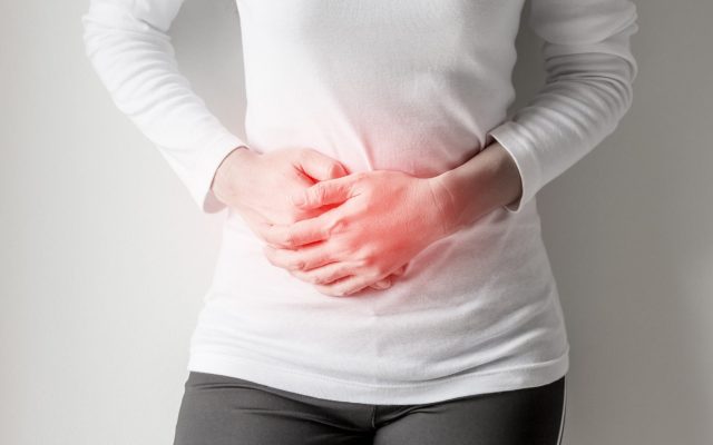 Person holding their stomach from pain.